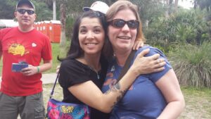 two people are hugging for a picture with a third talking from the side