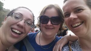 three people are leaning into a camera closely for a selfie