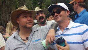 two people are posing for a photo with a third making a face in the background