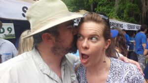 one person is kissing another's cheek while she is making a comical face