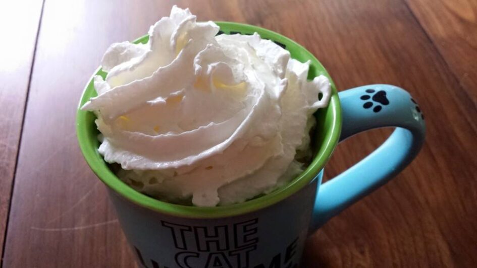 a coffee cup is full of spray whipped cream