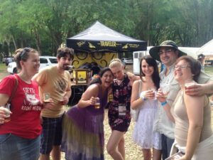 a group of people are posing for a photo at an outdoors event surrounded by beer tents