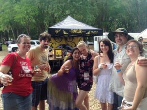 a group of people are posing for a photo at an outdoors event surrounded by beer tents
