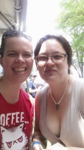 selfie of two people with one leaning forward to highlight her bosom