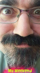 close up of a man's face with bear and glasses