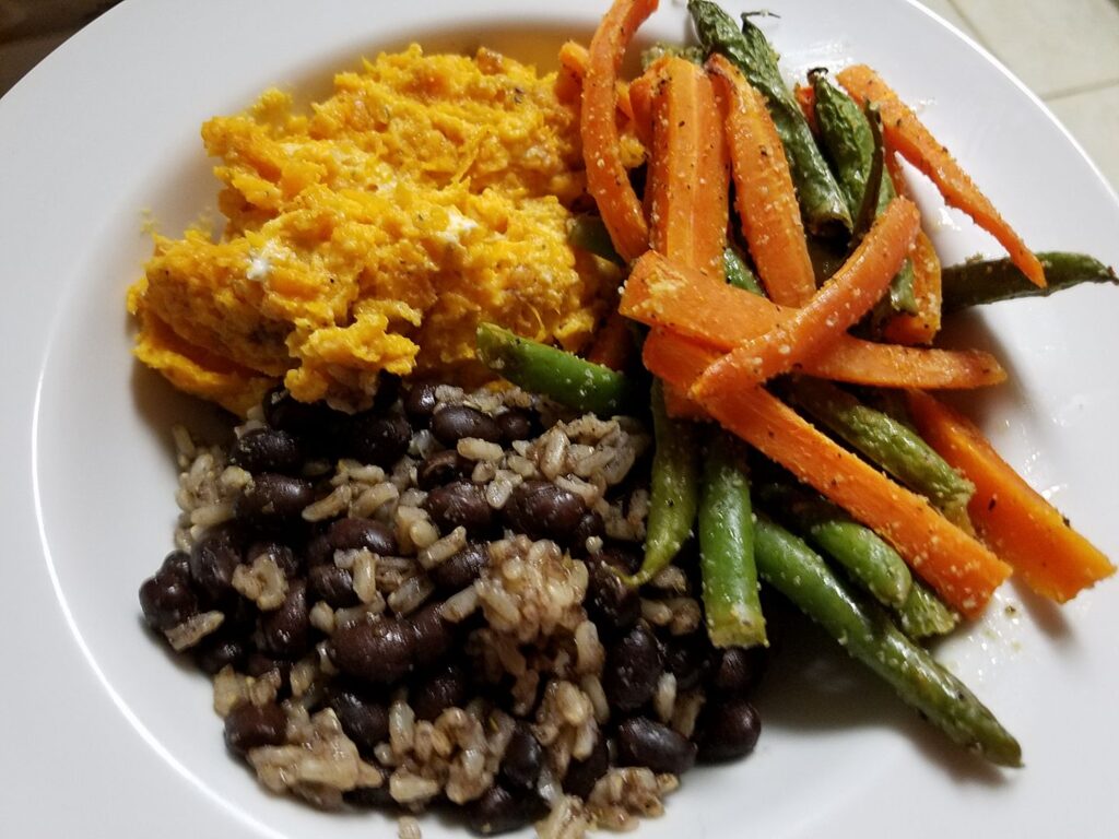 a bowl of beans and rice, sweet potatoes and carrots and green beans