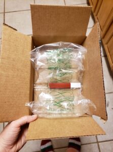a large box with padding has a small red tube packed in it