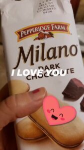 a hand holding a bag of Milano cookies