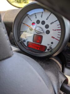 a car speedometer dial with a digital odometer in the base of it