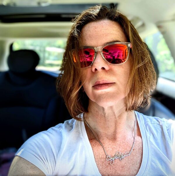 selfie of a person in a car wearing sunglasses and looking serious