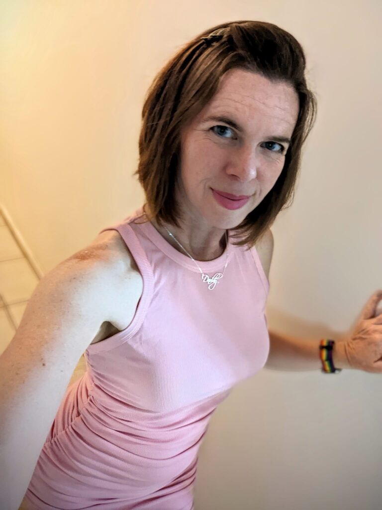 selfie of a person in pale pink