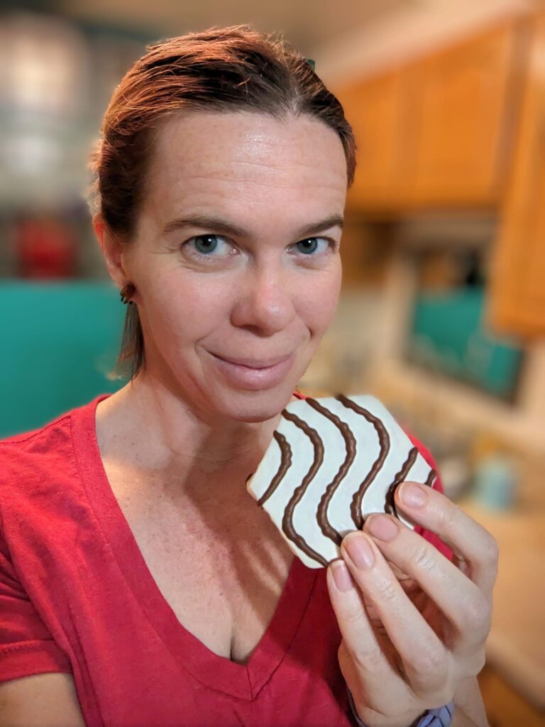 a person smiling and about to eat a little cake
