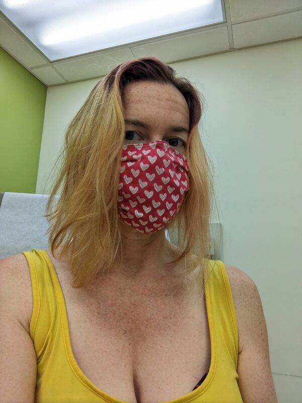 selfie of a person wearing a mask and sitting in what could be a doctor's office