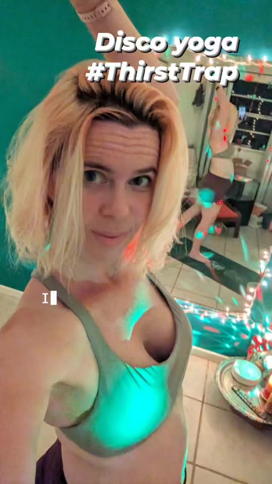 selfie of a person doing yoga in a room with bright disco lighting