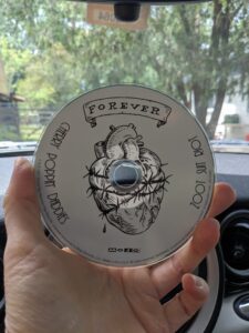 A hand holding up a Cherry Poppin Daddies CD