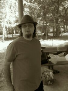a person in a hat is making a face at the camera in a park