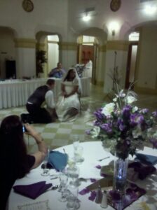blurry shot of a groom kneeling at his bride's feet for some reason