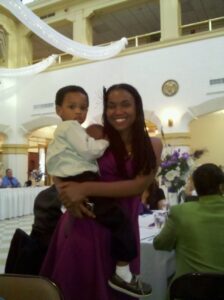 a person is holding a young child on her him at a semi-formal event
