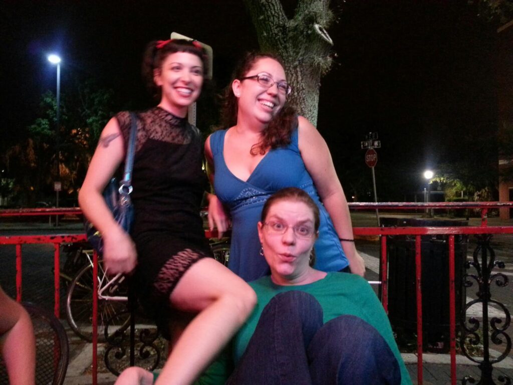 three ladies are posing dramatically on the patio of a bar