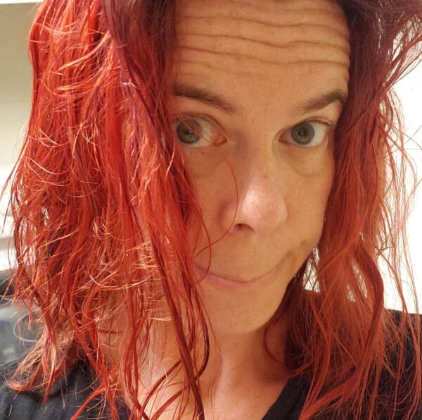 selfie of a person with wet vibrant red hair