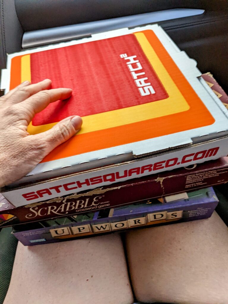 a person has several boxes stacked in her lap in a car