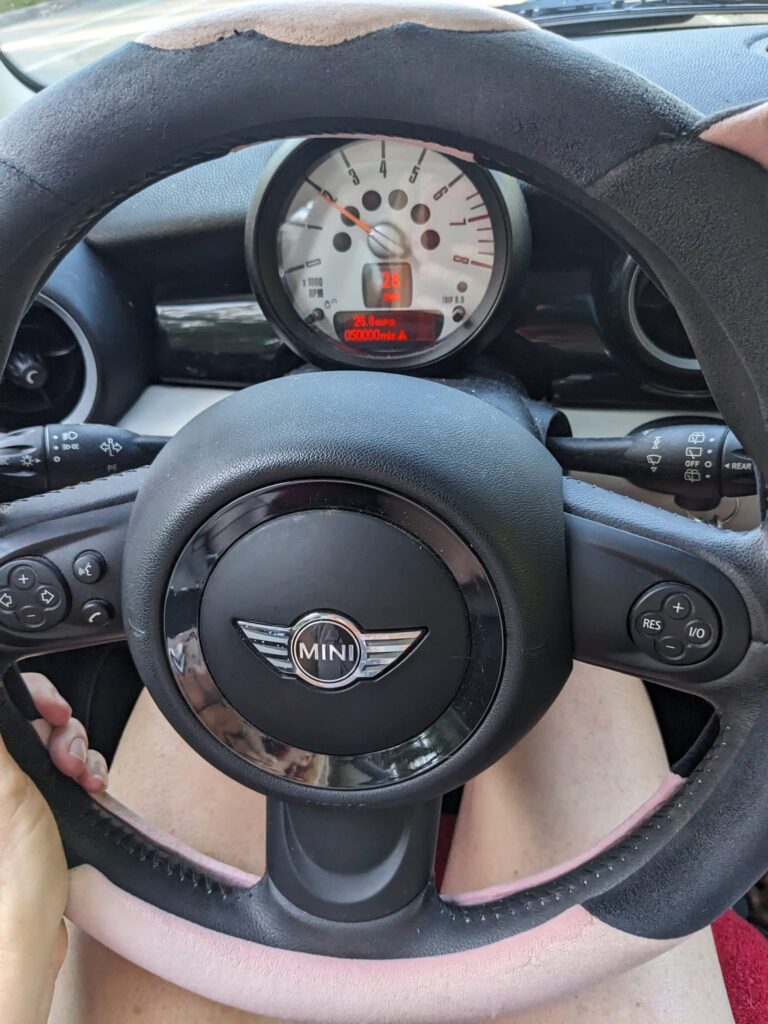 the steering wheel and dash of a Mini Cooper