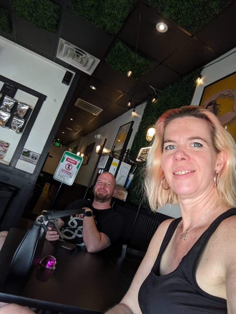 selfie of two people in a tiny restaurant of some kind