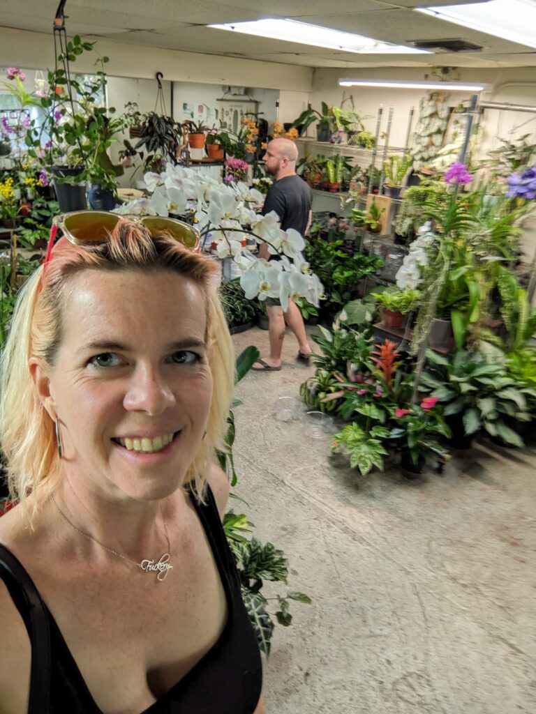 a person is taking a selfie in a plant shop