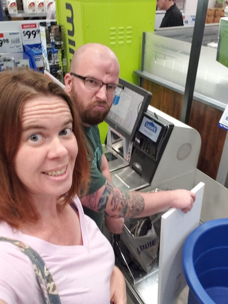 two people at a self checkout at a hardware store