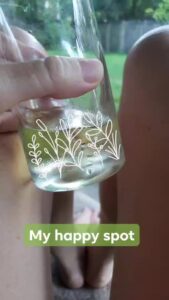 a hand is holding up a water glass