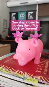 a toy pig is sitting on a stack of books