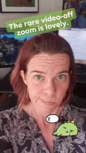 selfie of a person making a face with two computer monitors behind them
