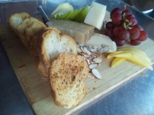 a plate has a selection of fruit and bread and cheese artfully arranged