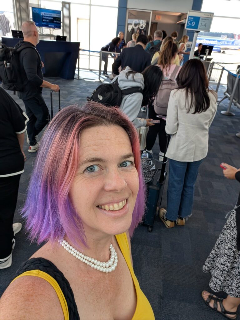 selfie of a person standing at the end of a line possibly at an airport