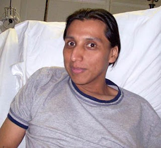 a person in a gray t-shirt sitting in bed